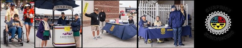 A group of people standing around an outdoor table.