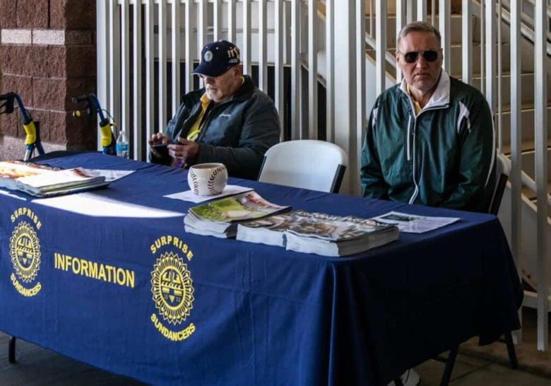 A group of people sitting at a table with papers.