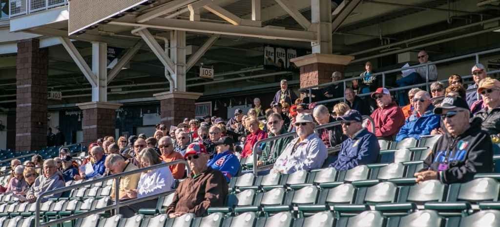 A group of people sitting in seats at a baseball game.