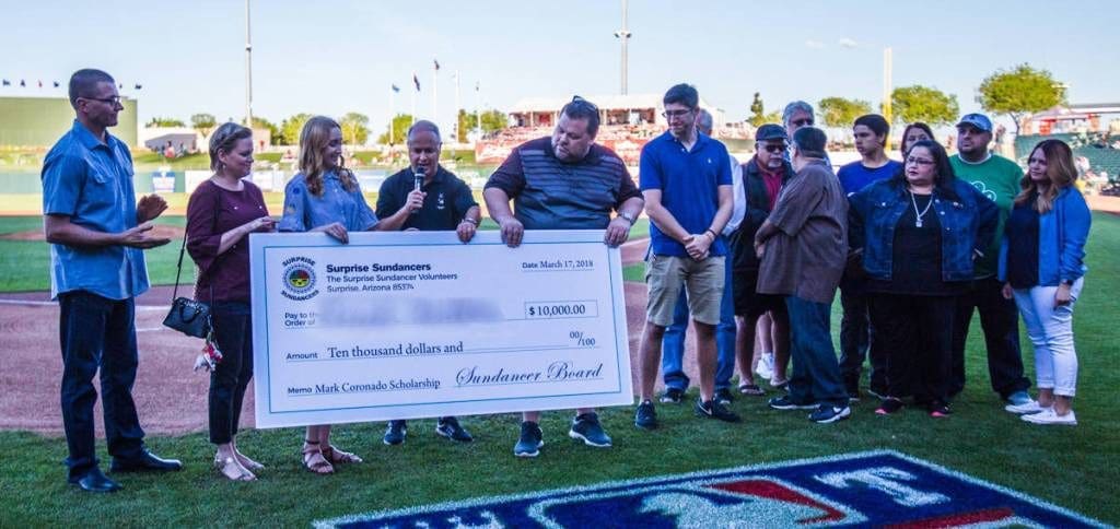 A group of people holding up large check