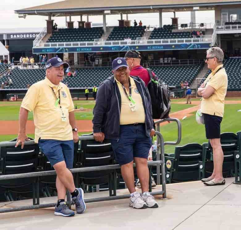 A group of people standing on top of a baseball field.