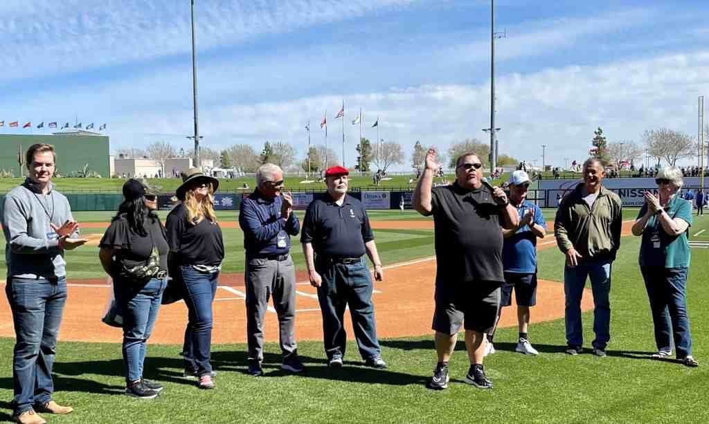 A group of people standing on top of a baseball field.