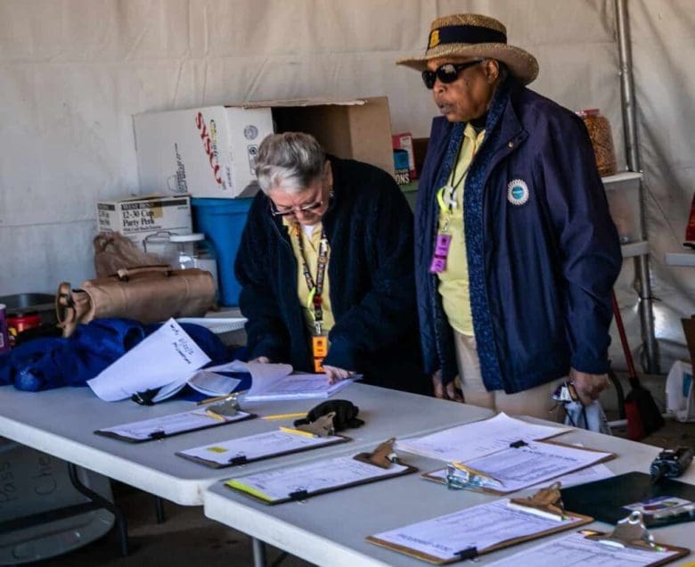 Two people standing at a table with papers on it.