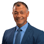 A man in a suit and tie smiling for the camera.