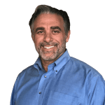 A man in blue shirt smiling for the camera.